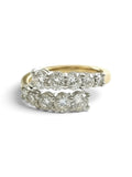 A yellow gold ring with a row of round-cut diamonds set in a silver-toned band, shown on a plain white background.