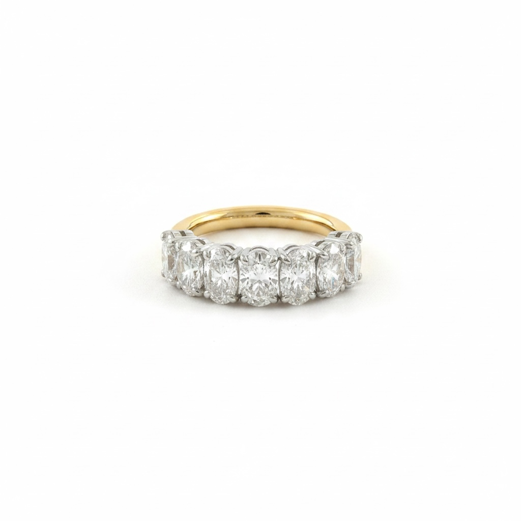 A diamond band ring featuring five round-cut diamonds set in a yellow gold band, photographed on a clean white background.