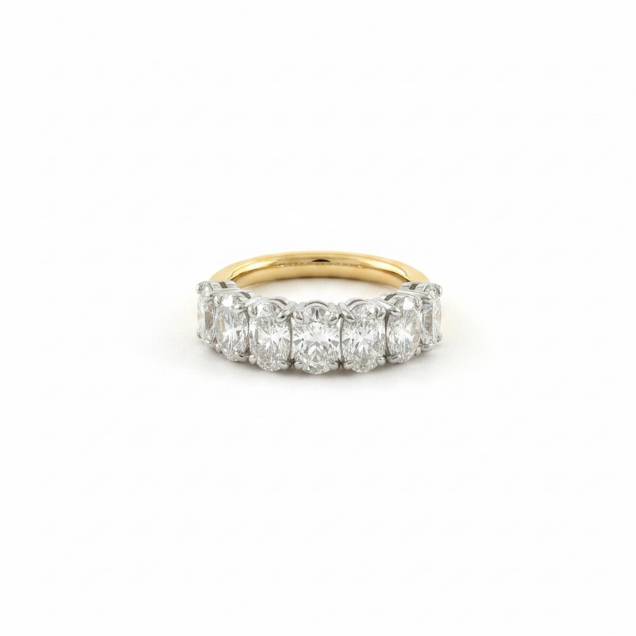 A diamond band ring featuring five round-cut diamonds set in a yellow gold band, photographed on a clean white background.