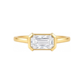 A yellow gold ring featuring a large rectangular emerald-cut clear gemstone in a prong setting, shown against a plain white background.