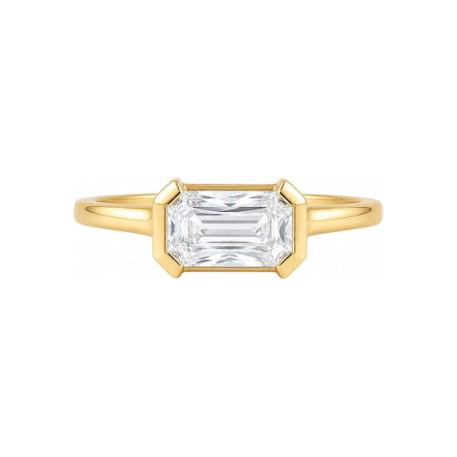 A yellow gold ring featuring a large rectangular emerald-cut clear gemstone in a prong setting, shown against a plain white background.
