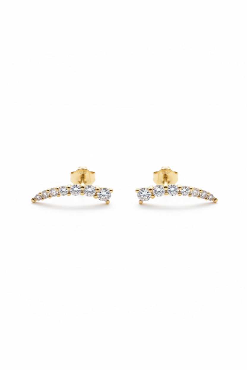 A pair of gold crescent-shaped stud earrings set with small clear stones, displayed on a clean white background.
