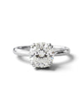 A classic solitaire engagement ring featuring a round brilliant-cut diamond set in a polished silver-colored metal band, shown against a clean white background with a soft shadow.