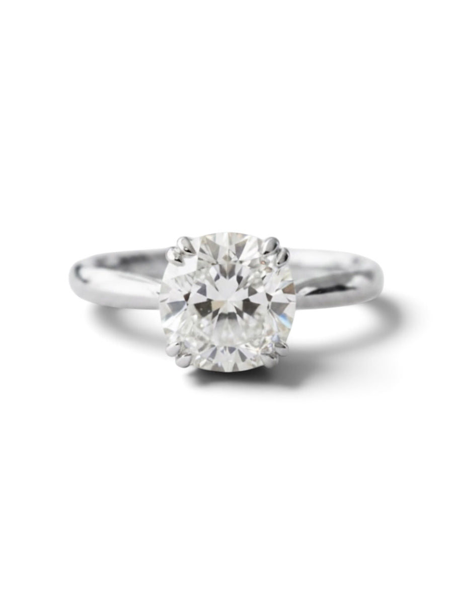 A classic solitaire engagement ring featuring a round brilliant-cut diamond set in a polished silver-colored metal band, shown against a clean white background with a soft shadow.