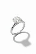 A classic solitaire engagement ring featuring a round brilliant-cut diamond set in a polished silver-colored metal band, photographed on a clean white background with a soft shadow.